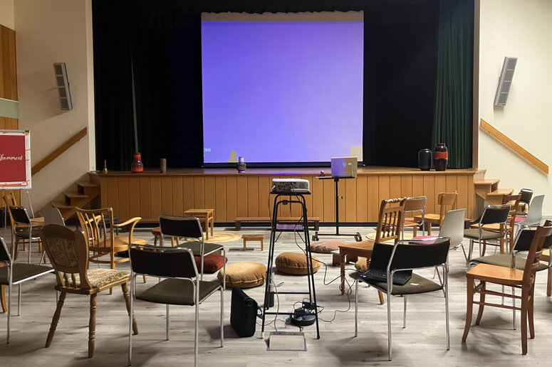 Ein leerer Tagungsraum mit Stühlen und Tischen.