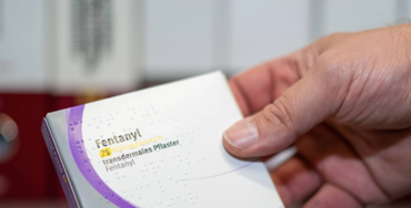 Das Foto zeigt einen Fentanyl-Pflaster-Verpackung, die von einer männlichen Hand in die Kamera gehalten wird. Sie enthält den Schriftzug: "Fentanyl  - transdermales Pflaster"