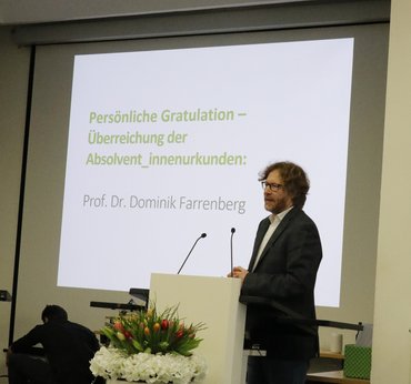 Dominik Farrenberg steht auf der Bühne am Rednerpult