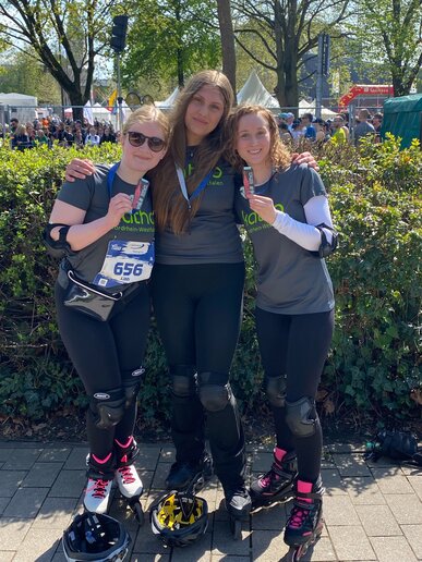 Die Läuferinnen des Inliner Skate Race zeigen stolz ihre Medaillen.