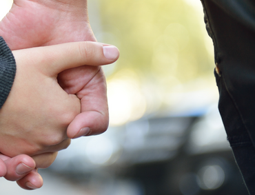 Hand eines Kindes wird von der Hand eines erwachsenen gehalten.