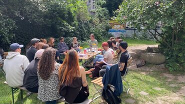Studierende sitzen zusammen und diskutieren über die Herausforderungen der Sozialen Arbeit zu Zeiten der Wende und heute