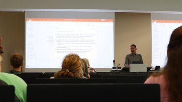Ein Professor beim Vortrag vor Zuschauerschaft im Hörsaal