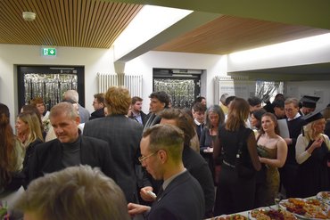 In der Cafeteria gibt es Fingerfood, es stehen Gruppen zusammen und unterhalten sich