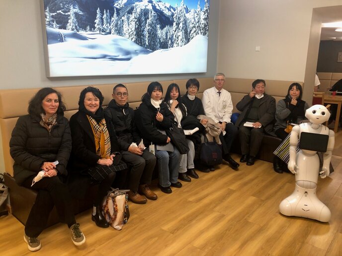 Gruppenbild mit Arzt und Roboter.