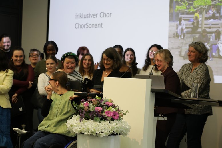 Liane Schirra-Weirich steht auf der Bühne und bedankt sich beim Chor 