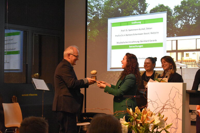 Mehrere Frauen auf der Bühne übergeben Christof Stock ein Geschenk.