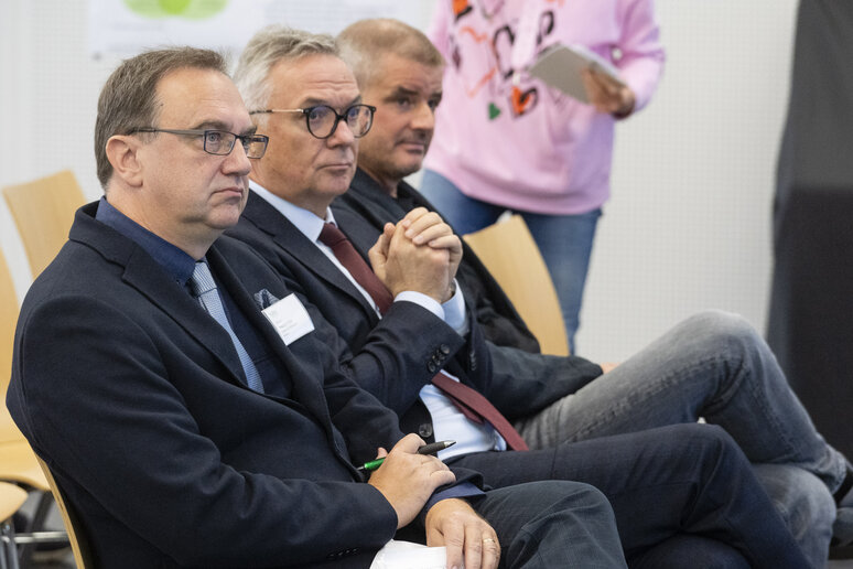 Drei Herren hören zu