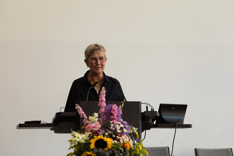 Die zu verabschiedende Kollegin hält ihre Abschlussrede auf der Bühne am Rednerpult.