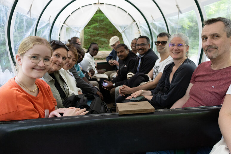 Personen sitzen in einer Kutsche und schauen freundlich in die Kamera.