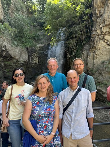 Eine Gruppe von fünf Personen vor einem Wasserfall.