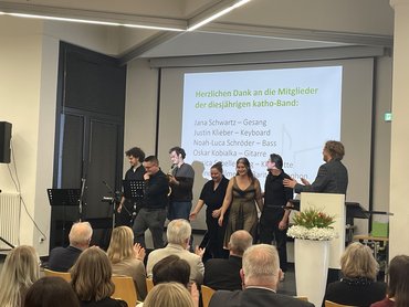 Die Bandmitglieder stehen auf der Bühne gemeinsam mit Domink Farrenberg