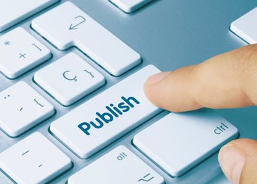Computertastatur, Finger tippt auf Taste mit Aufschrift "Publish"