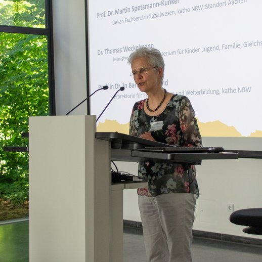 Barbara Ortland steht in der vollen Aula am Rednerpult