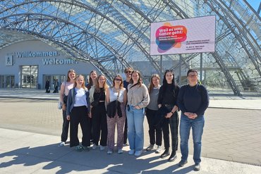 Seminarteilnehmer_innen stehen lächelnd vor dem Eingang des Tagungshauses in Leipzig