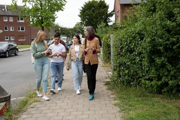 Eine Gruppe aus vier Leuten im Gespräch während eines Spazierganges.