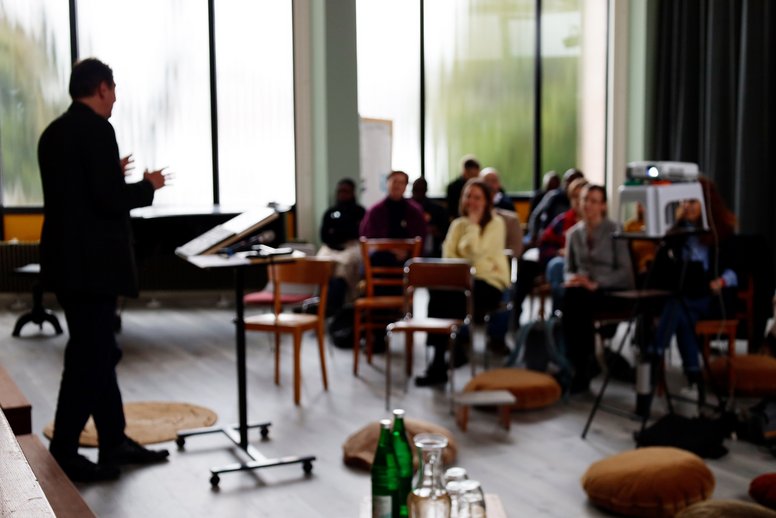Einblick in eine Veranstaltung der Tagung mit Redner und Zuhörenden.