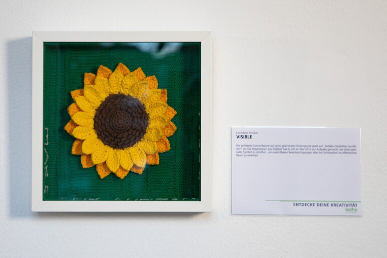 Bild (gestrickte Sonnenblume) mit Erklärungstext.