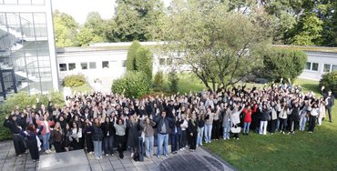 180 Studierende stehen im Garten der katho.