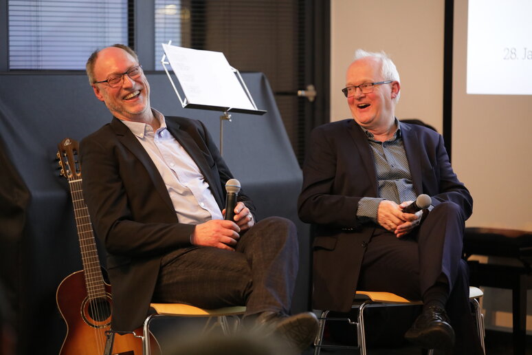 Beide Männer lachen auf der Bühne