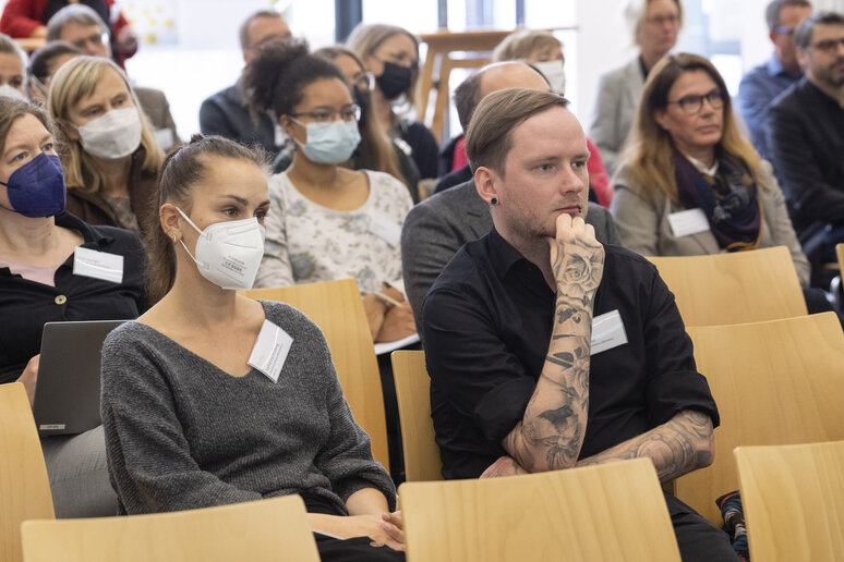 Menschen in Sitzreihen hören zu