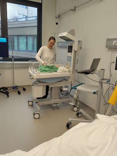 Frau Labenz befindet sich am Skills Lab und steht an einem Krankenbett.