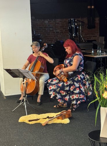 Zwei Musikerinnern musizieren sitzend
