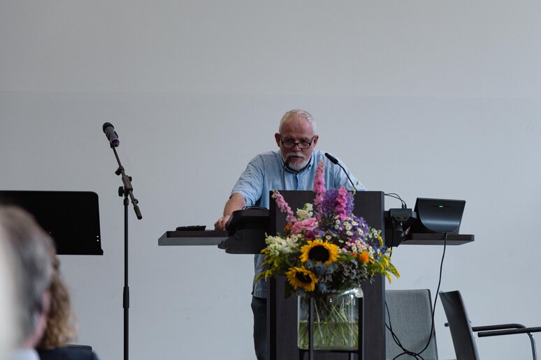 Der zu verabschiedende Kollege hält seine Abschlussrede auf der Bühne am Rednerpult.