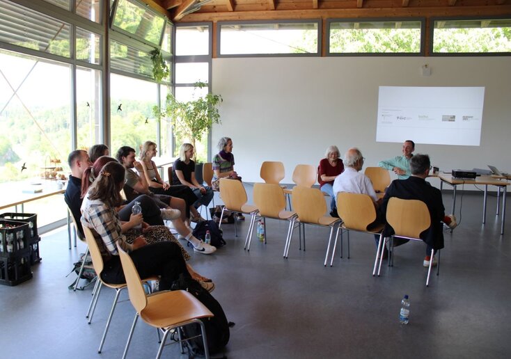 Das Publikum sitzt im Vortragssaal und wartet.