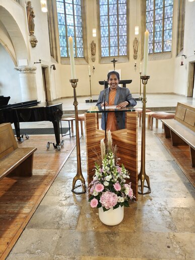 Eine Studentin begrüßt die neuen Studierenden in der Petrikirche.