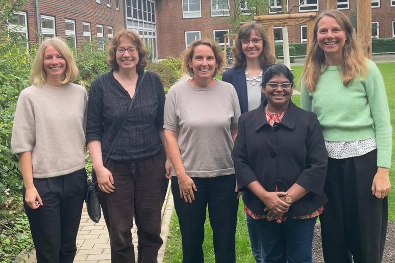 Eine Gruppe von sechs Frauen steht auf dem Campus der katho am Standort Münster und lächeln in die Kamera.