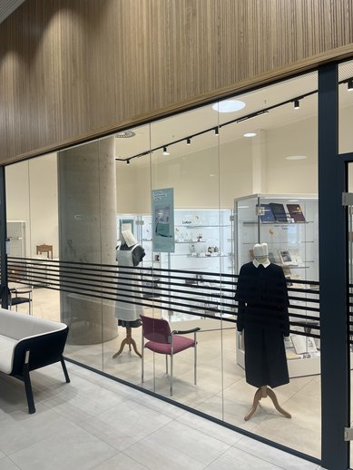 Blick in das Museum zur Entwicklung der Pflege. Man sieht Berufskleidung aus früheren Zeiten