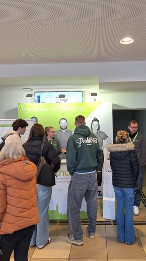 Studieninteressierte im Gespräch am Infostand der katho