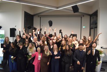 Die Graduierten werfen die Hüte in die Luft