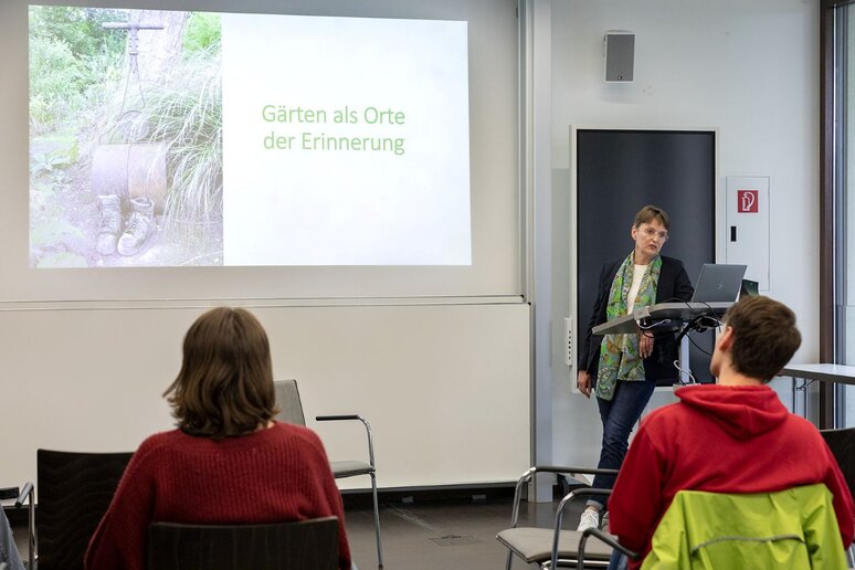 Eine Frau steht vor eine Gruppe Studierender und hält einen Vortrag. Bei der Frau handelt es sich um die Gartenexpertin Antje-Peters Reimann.
