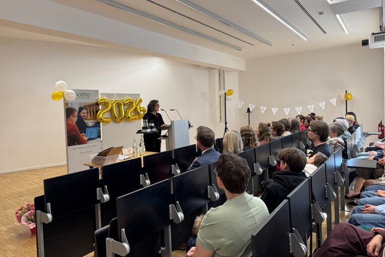 Auf dem Bild sind volle Sitzreihen und die Studiengangsleitung am Rednerpult abgebildet