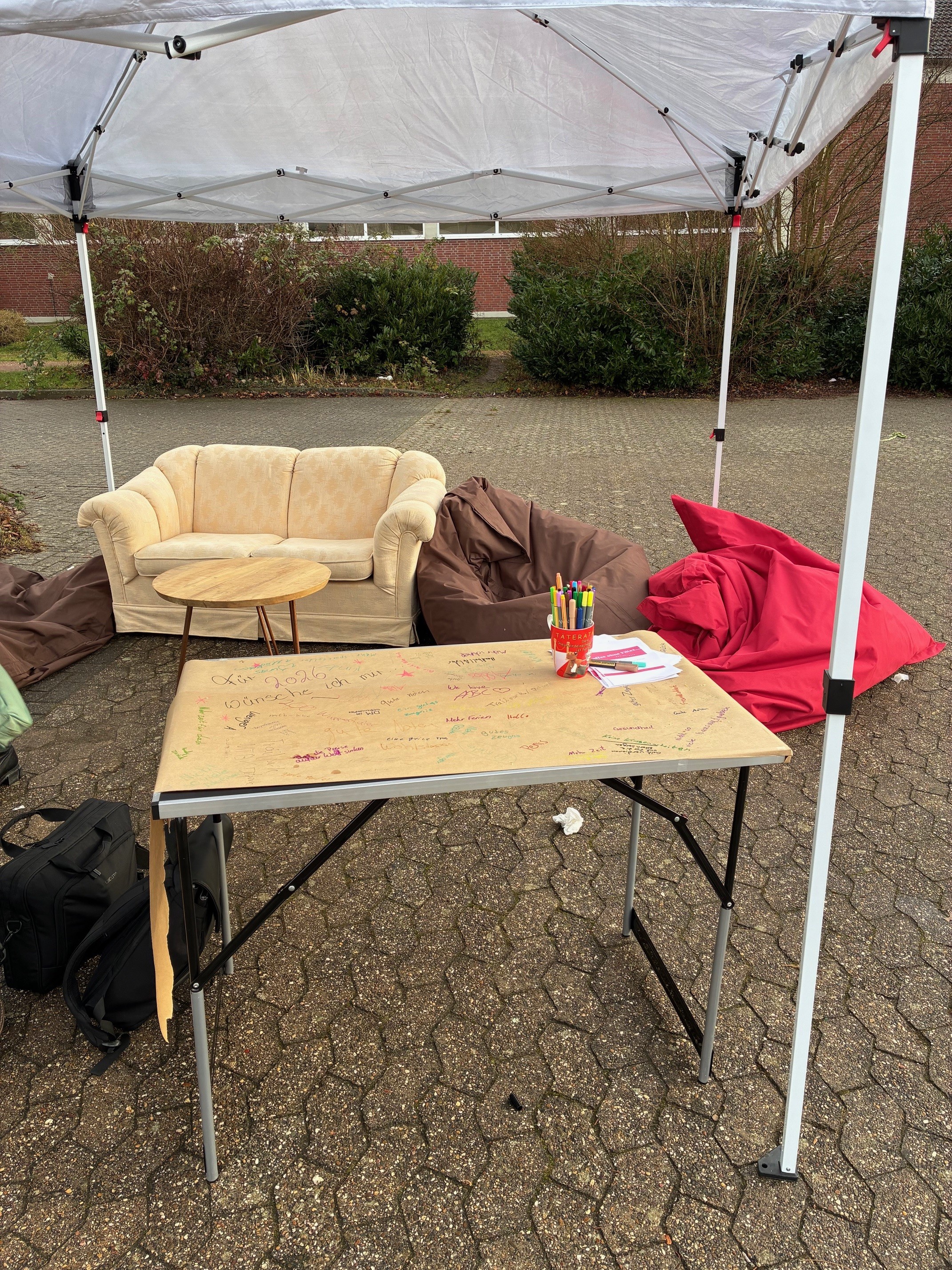 Im Vordergrund steht ein Klapptisch, dahinter ein Sofa und zwei Sitzsäcke.