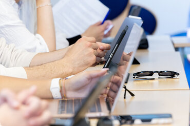 Studierende notieren sich etwas während  einer Vorlesung.

