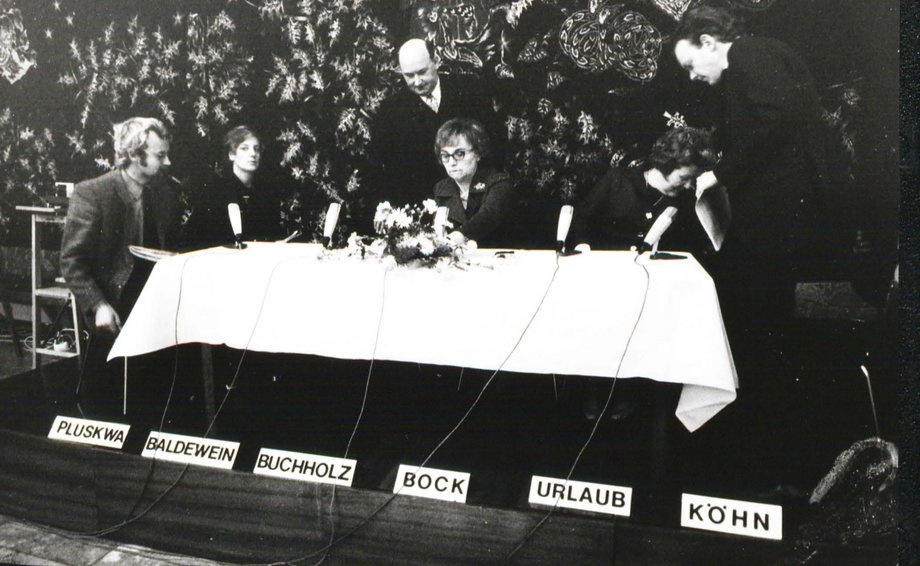 Historisches Foto zur Gründung der katho: Rektorin Theresa Bock und andere sitzen an einem Tisch.