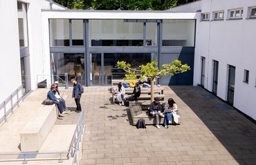 Studierende halten sich am Campus der Hochschule auf.

