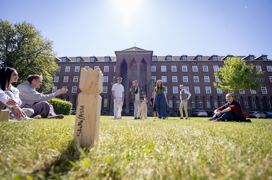 Studierende halten sich am Campus der Hochschule auf und spielen Wikinger-Schach.

