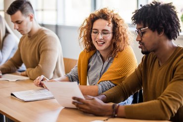 Eine Studentin arbeitet mit ihrem Kommilitonen zusammen im Seminarraum.