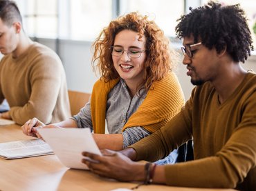Eine Studentin arbeitet mit ihrem Kommilitonen zusammen im Seminarraum.