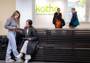 Studierende halten sich halten sich im Foyer auf.

