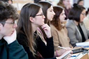 Mehrere Studierende sitzen in einem Seminar zusammen.
