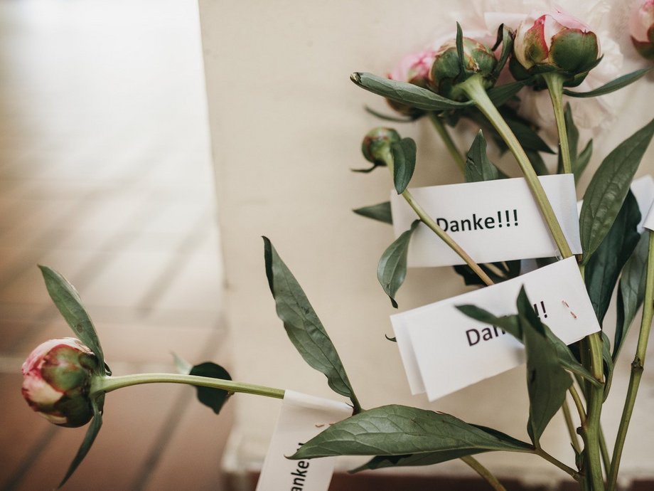 An einem Bund Blumen sind Zettel mit der Aufschrift "Danke" befestigt.