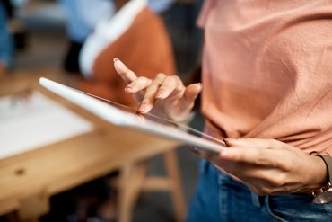 Eine Person hält ein Tablet in ihrer Hand.