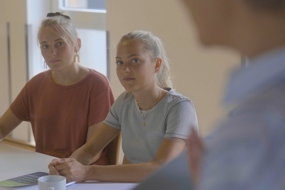 Zwei Studentinnen folgen den Ausführungen ihrer Professorin.