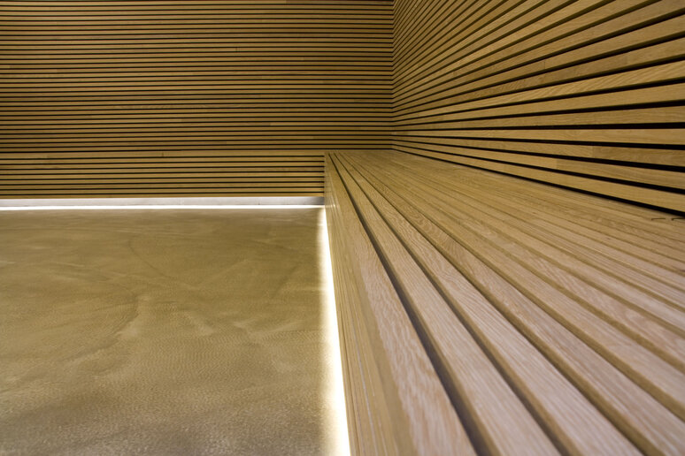 Raumwand und Bank aus warmen Holzpaneelen