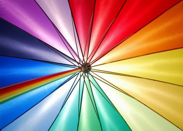 Ein Regenschirm in Regenbogen Farben wurde von unten fotografiert.